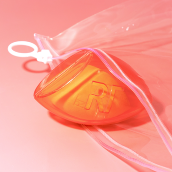 Pomarańczowa gąbeczka Real Techniques Miracle Complexion Sponge do podkładu w przezroczystym etui, widok z góry.