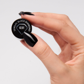 Zakrętka lakieru Semilac 031 Black Diamond (głęboka czerń) w dłoni z czarnymi paznokciami.