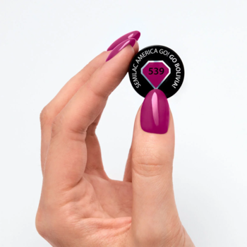 Lakier hybrydowy Semilac 539 Go Bolivia!, intensywny burgund z fioletem. Dłoń z paznokciami trzyma wzornik koloru.