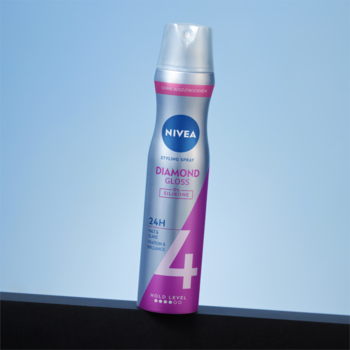 Pionowy lakier NIVEA Diamond Gloss w srebrno-różowej butelce na tle błękitnego nieba, widok z przodu.