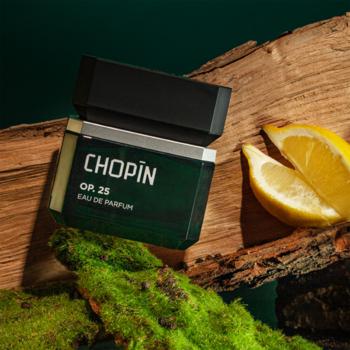Woda perfumowana Chopin OP.25 w zielonej butelce z czarną nakrętką, leży na drewnie i mchu obok cytryn.