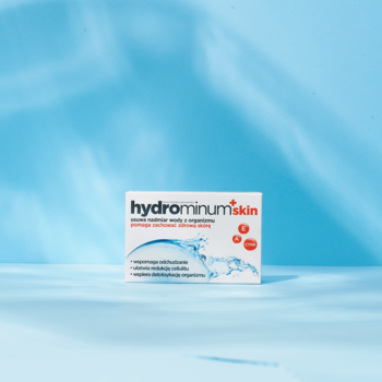 Hydrominum Skin suplement diety w białym pudełku z czerwonym napisem, na tle niebieskiej ściany z cieniem.