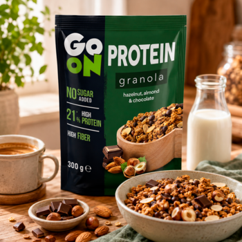 GO ON Protein Granola orzech, migdał, czekolada, bez cukru, w czarno-zielonej torebce na stole z miską.