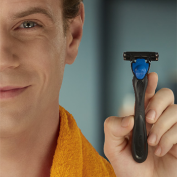 Uśmiechnięty mężczyzna prezentuje golarkę BIC Hybrid 3 Flex z 3 ruchomymi ostrzami dla idealnie gładkiego golenia.