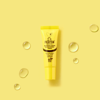 Żółty balsam Dr.PawPaw Original Lip Balm, 100% naturalny, na żółtym tle z lśniącymi kroplami oleju.