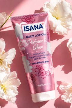 Różowy balsam do ciała Isana Perfume & Glow z kwiatowym wzorem na tubce, leżący wśród białych kwiatów.
