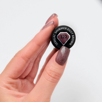 Dłoń trzyma wieczko lakieru hybrydowego Semilac 322 Shimmer Dust & Brown, z paznokciami w chłodnym, brokatowym brązie.