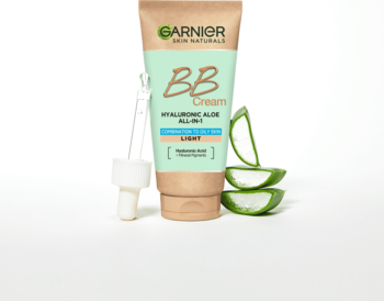 Beżowo-miętowy krem BB Garnier Hyaluronic Aloe Light, tuba z aplikatorem obok plastrów aloesu.