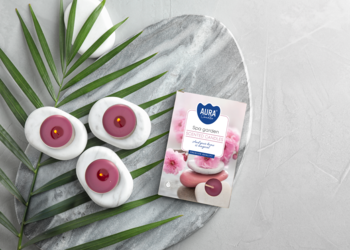 Trzy białe świece zapachowe Ogród SPA z różowym środkiem, opakowanie Rose Garden, na marmurowej tacy.