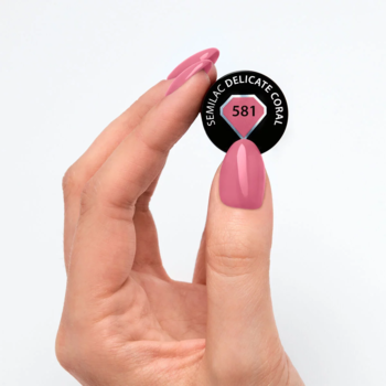 Zbliżenie dłoni z lakierem Semilac Delicate Coral, trzymającej czarny wzornik 581 Delicate Coral.