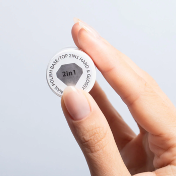 Zbliżenie na białą nakrętkę Bazy/Topu 2w1 Hard & Glossy do lakierów klasycznych, trzymaną w dłoni.