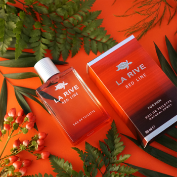 La Rive Red Line męska woda toaletowa 90 ml. Czerwono-pomarańczowa butelka i pudełko wśród zielonych liści.