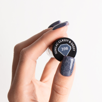 Zbliżenie na lakier Semilac Classy & Sassy 398, ciemnoszary z błyszczącymi drobinkami, trzymany w dłoni, paznokcie pomalowane.
