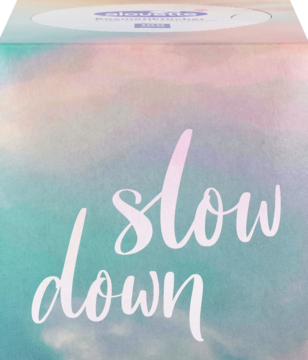 Zbliżenie na chusteczki kosmetyczne w pastelowym opakowaniu z białym napisem "slow down" na akwarelowym tle.