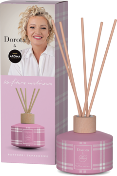 Różowy dyfuzor zapachowy Aroma Home Dorota Szelągowska, z patyczkami, obok pudełka w kratkę, zapach malinowy.
