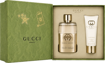 Otwarty zestaw Gucci Guilty Pour Femme: zielone pudełko, butelka wody toaletowej i biały balsam do ciała.