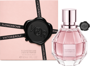 Różowy flakon perfum Flowerbomb Viktor & Rolf w kształcie diamentu obok pudełka z czarną pieczęcią VOR.