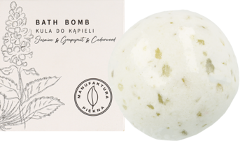 Kremowa kula do kąpieli Jasmin & Grapefruit & Cedarwood z zielonymi drobinkami, obok etykieta.