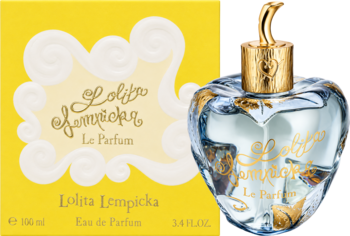 Lolita Lempicka Le Parfum, sercowata butelka z niebieskawym płynem i złotym korkiem obok żółtego pudełka z logo.