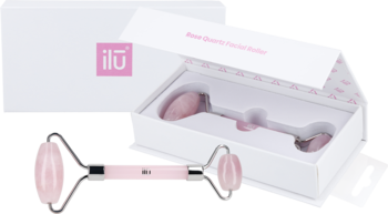 Ilū różowy roller kwarcowy do masażu twarzy, dwustronny, leży obok otwartego pudełka z logo.