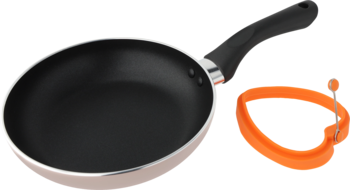 Czarna patelnia nieprzywierająca z srebrnym brzegiem, widok z góry, obok pomarańczowa forma serce z płynem.