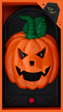 Halloweenowy dzwonek w formie pomarańczowej dyni z wściekłymi oczami, funkcją "Try Me", w otwartym pudełku.