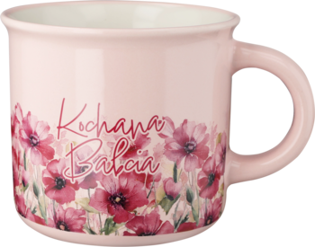 Ceramiczny kubek w pastelowym różu z napisem 'Kochana Babcia' i kwiecistym wzorem czerwonych maków, widok z boku.