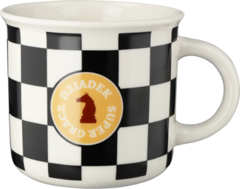 Kubek w czarno-białą szachownicę z okrągłą, żółtą etykietą: "DZIADEK SUPER GRACZ" i figurą szachową, widok z przodu.