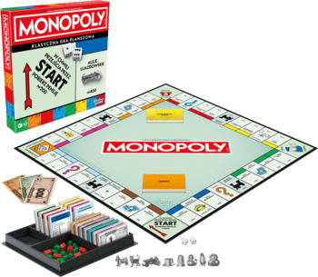 Gra planszowa Monopoly: na całego albo wcale! rozłożona z pudełkiem i akcesoriami na stole.