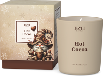 Świeca sojowa Hot Cocoa w beżowym słoiku obok otwartego pudełka z zimowym gnomem i płatkami śniegu.