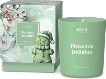 Zielona świeca sojowa EZTI "Pistachio Delights" w matowym słoiku, obok pudełko z piernikowym ludzikiem.