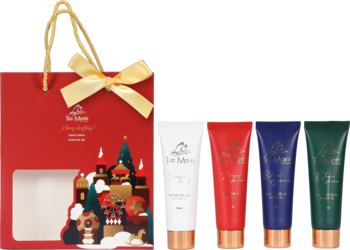 Czerwona torba prezentowa De Meton z motywem świątecznym i cztery tubki kremów do rąk De Meton.