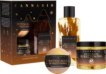 Zestaw Cannabio Złoto Bałtyku: olejek, kula musująca i sól bursztynowa z przodu, obok ozdobnego pudełka prezentowego.
