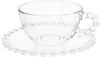 Przezroczysta szklana filiżanka z uszkiem i koralikami na brzegu, na okrągłym spodku z falbanką, widok z przodu.