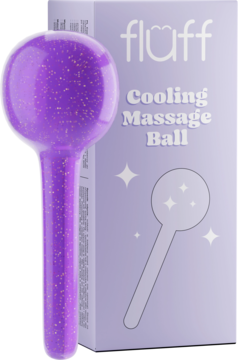 Fioletowy, brokatowy Fluff Cooling Massage Ball z rączką, stojący przed jasnofioletowym opakowaniem.