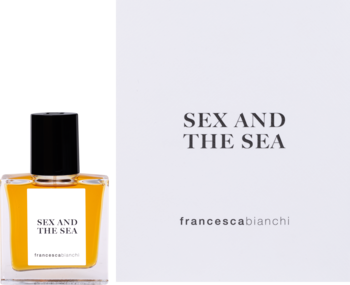 Perfumy Francesca Bianchi Sex And The Sea, bursztynowa butelka obok białego pudełka z nazwą produktu.
