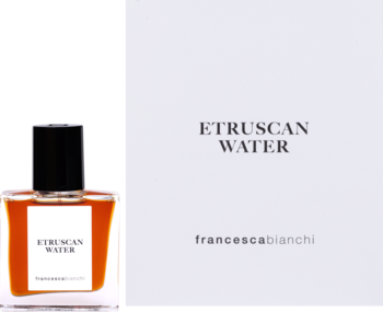 Perfumy Francesca Bianchi Etruscan Water, aromatyczne. Bursztynowa butelka obok białego pudełka, widok z przodu.