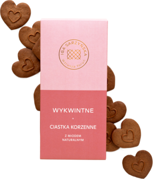 Różowo-czerwone pudełko Wykwintnych Ciastek Korzennych z Miodem Naturalnym IGA SARZYŃSKA, otoczone serduszkami.