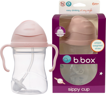 Różowy bidon b.box z obciążoną słomką i uchwytami, obok jego fioletowe opakowanie. Widok z przodu.