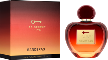 Perfumy Banderas Her Secret Prive w sercowatej butelce ombre czerwono-złotej, obok pudełka, widok z przodu.