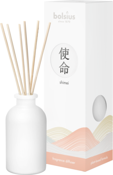 Biały ceramiczny dyfuzor zapachowy Bolsius Shimei z patyczkami, obok białe opakowanie z napisem i grafiką.