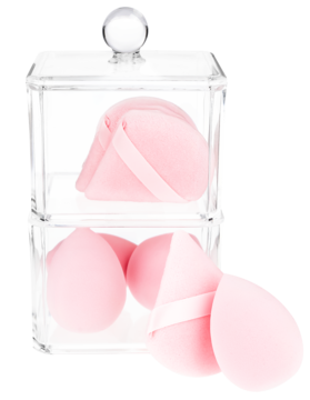 Różowe gąbeczki do makijażu w kształcie łezki i trójkąta w przezroczystym, piętrowym organizerze na kosmetyki.