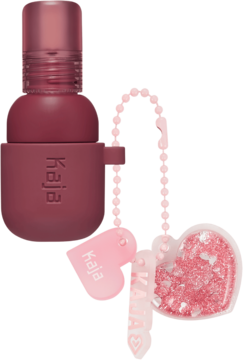 Kaja Jelly Charm Fig Soda, matowy róż/pomadka 2w1 w bordowej butelce z logo i różowym breloczkiem serca.