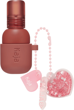 Kaja Jelly Charm Peach Fizz, róż i pomadka 2w1. Terracottowa buteleczka z różową zawieszką i dwoma sercami.