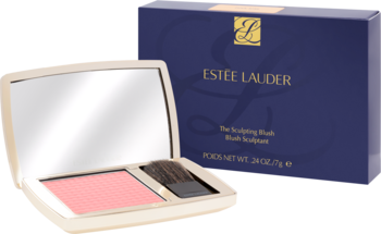 Otwarty kompakt Estée Lauder z bladoróżowym różem do policzków, pędzelkiem i lusterkiem, z tyłu granatowe pudełko.