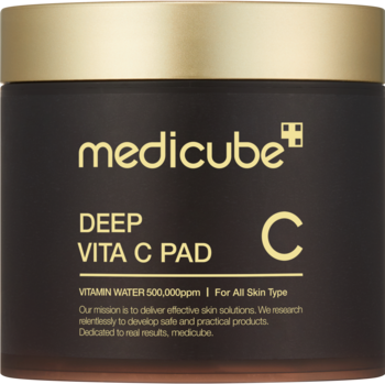 Medicube Deep Vita C Pad, rozjaśniające płatki do twarzy, w okrągłym, ciemnym słoiku ze złotą pokrywką, widok z przodu.