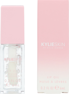 Kylie Skin Lip Oil w przezroczystej butelce z różową nakrętką, obok jasnoróżowego kartonika, widok z przodu.