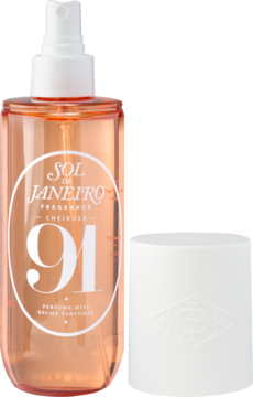 Sol de Janeiro Cheirosa '91 Bruma Perfumada w pomarańczowej butelce z białą etykietą, obok biała nakrętka.
