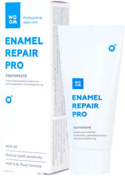 WOOM Enamel Repair Pro pasta do zębów, biała tubka i pudełko z niebieskimi napisami, widok pod kątem.