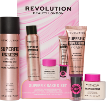 Zestaw Revolution Superfix z różowo-złotymi sprayami, primerem, pudrami Translucent i Super Grip stick na różowym tle.